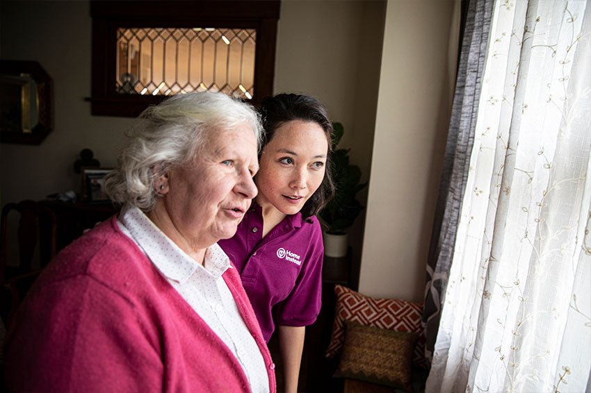 A professional caregiver providing companionship to an elderly woman.